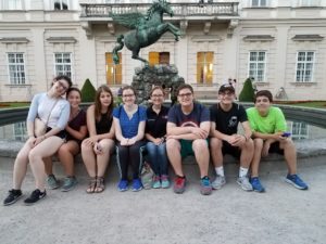 Group of Padua Franciscan High School sitting in front of a statue with a horse