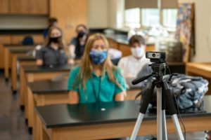 A Padua Franciscan High School teacher wearing a mask and being recorded on a camera talking about the covid pandemic in 2020