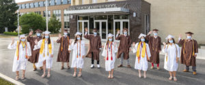 Padua Franciscan High School graduates wearing masks and waving outside of the school in Parma, OH
