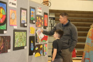 Father looking at artwork with his son at the Padua’s Elementary Art & Literary Show